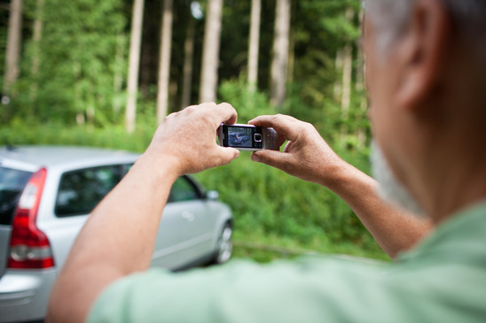 man taking picture of a car