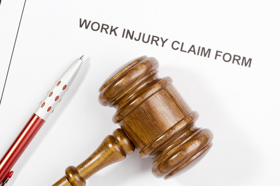Work injury claim form with judge’s gavel and pen