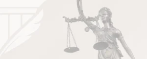 Statue of blindfolded Lady Justice holding scales, set against a light background with feather-shield branding, symbolizing fairness, impartiality, and legal authority.